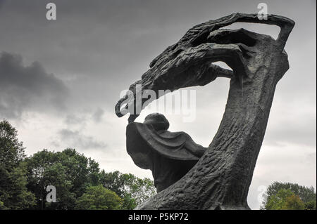 The Frederic Section of the Chopin monument by sculptor Waclaw Szymanowski, Royal Lazienki Park. Bronze statue, trees and moody grey sky Stock Photo