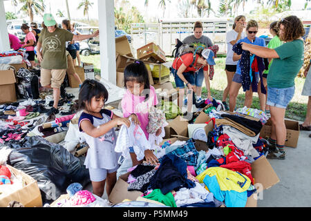 Everglades City Florida,after Hurricane Irma storm aid disaster assistance,distribution site donations free clothing pile,Hispanic women girls looking Stock Photo