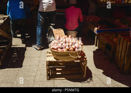 Wicker basket full of onions in the African market Stock Photo