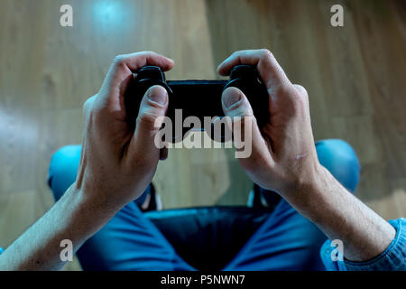 Addiction and dependency concept. close up on young mans hand with pad joystick playing video games Male addicted to console gaming concept. Stock Photo