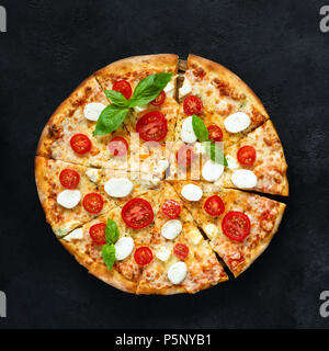 Pizza with mozzarella cheese, tomato and basil on black concrete background, top view, square crop Stock Photo