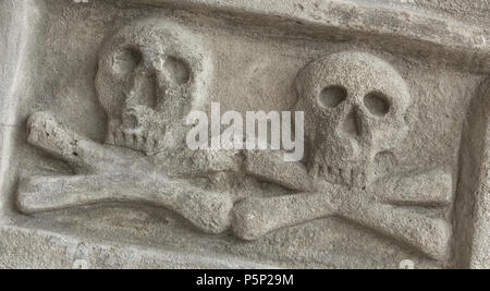 Ancient stone skull with crossbones. Old sculpture. Ideal for concepts and backgrounds. Stock Photo