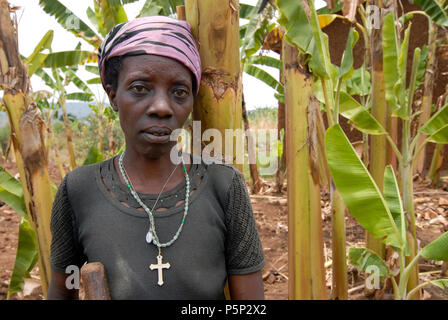 A Hutu woman and a Tutsi women who are friends stand outside a house ...