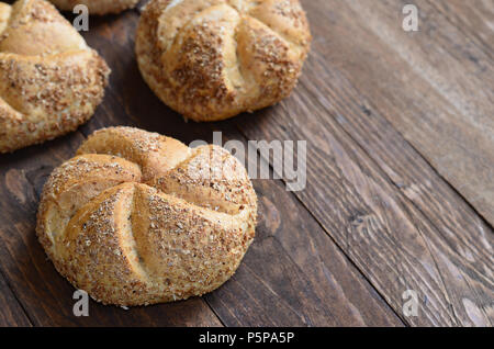 Multigrain Kaiser rolls on dark wooden background Stock Photo