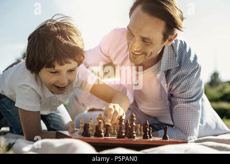 Smiling son and dad playing chess Stock Photo