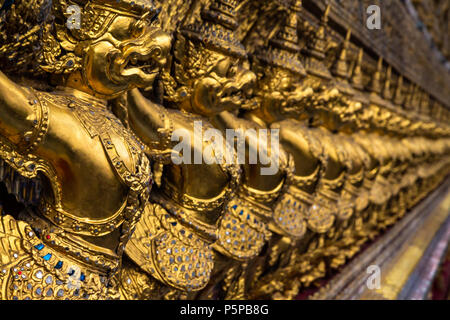 Row of golden Garuda figures from Thai mythology, adorning the interior of Wat Phra Kaew (Temple of the Emerald Buddha). Located in the Grand Palace, Stock Photo