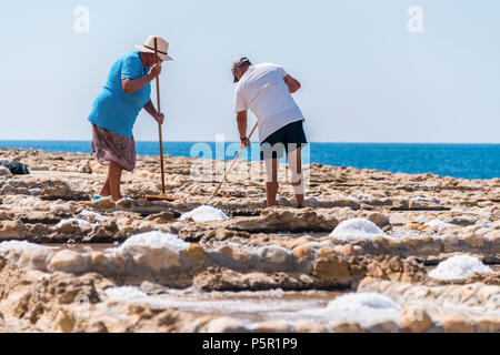 Harvesting sea salt from the ancient salt pans in Marsalforn, Gozo, Malta. Stock Photo