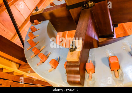 Gear mechanism, with replaceable wooden gear teeth inside the rotating roof of an old fashioned windmill. Stock Photo
