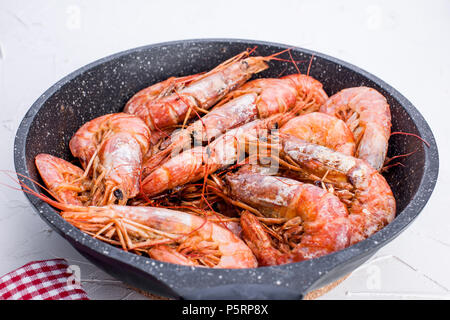 Large shrimps fried in a frying pan. On a white table. Lunch from seafood. Free space for text. Copy space Stock Photo