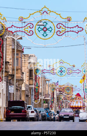 Colourful decorative arches are erected for the festival of Saint Peter and Saint Paul in Xwekija, Gozo, Malta. Stock Photo