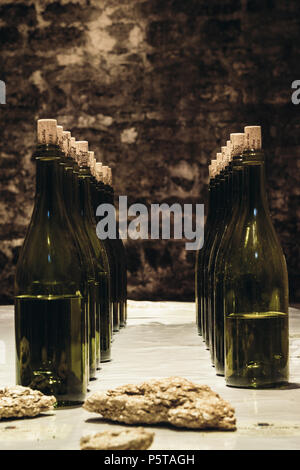 Bottles stand on a table in an old wine cellar, wine tasting Chablis, France. July 23, 2017 Stock Photo