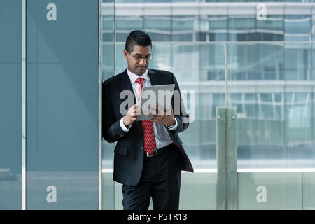 Indian businessman using a tablet PC indoors Stock Photo
