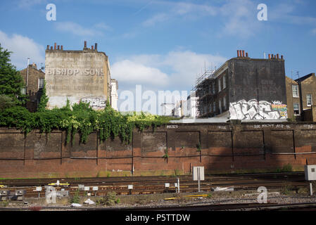 Difference between old style advertising and graffiti on the end of buildings Stock Photo