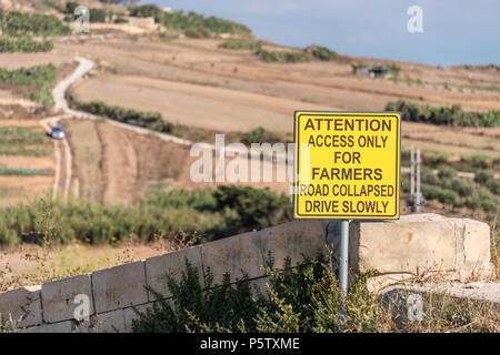 Sign advising motorists that a road has collapsed, and access is for farmers only, Xaghra, Gozo, Mallta Stock Photo