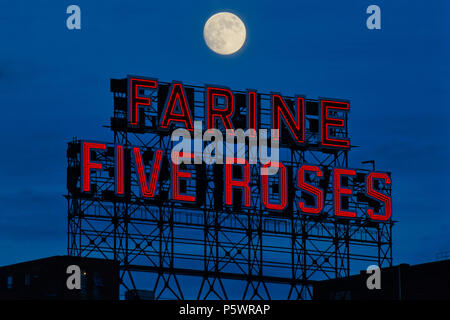 Montreal,Canada, 26 June 2018. Full moon rising over the iconic Farine Five Roses neon sign. Credit:Mario Beauregard/Alamy Live News Stock Photo