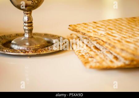 Jewish Passover concept illustration with matzah. Silver wine cup with matzah, Jewish symbols for the Passover (Pesach) holiday. Passover concept. Stock Photo