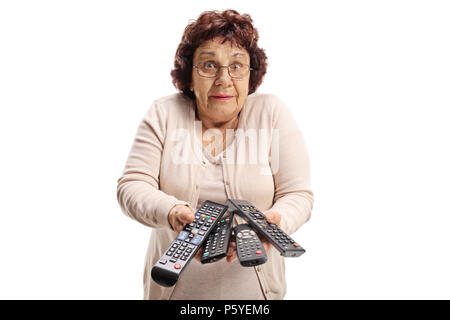Confused elderly woman with remote controls isolated on white background Stock Photo