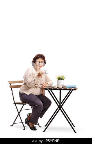 Mature woman sitting at a coffee table isolated on white background Stock Photo