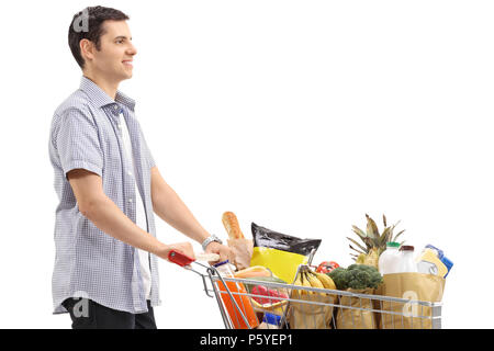 Young man with a shopping cart filled with groceries isolated on white background Stock Photo
