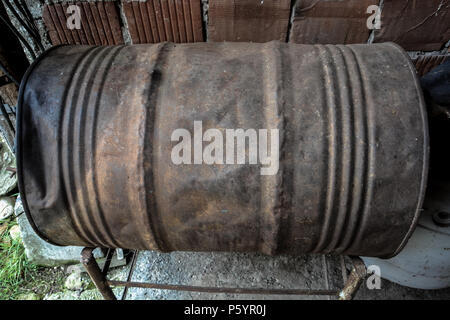 Lonely rusty barrel.Empty fuel barrel in the wood of an area with neglected land.Industry oil barrels or chemical drums stacked up Stack Of Oil barrel Stock Photo
