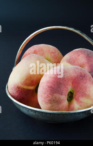 Saturn peaches or donut, UFO, flat peaches on black background Stock Photo