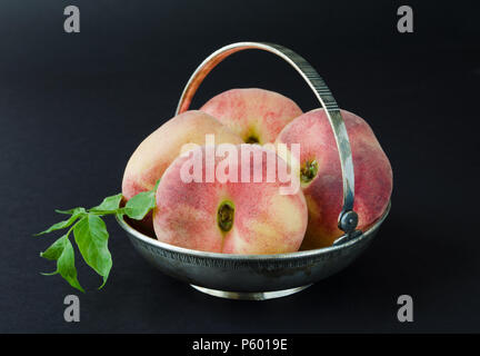 Saturn peaches or donut, UFO, flat peaches on black background Stock Photo