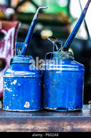 Old dirty metal blue oil cans sitting on the back of a steam tractor Stock Photo