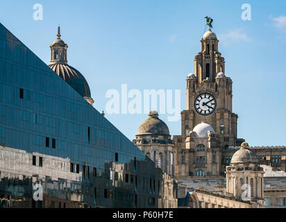 View of tower of Royal Liver building with UK largest clock and Liver bird, Pier Head, Liverpool, England, UK with modern glass building reflections Stock Photo