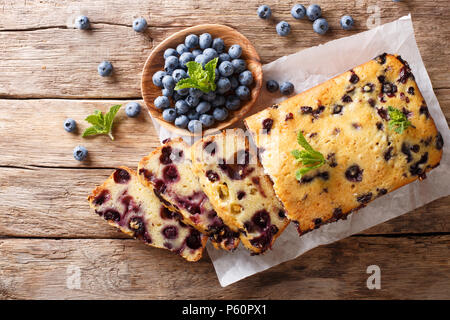 fresh blueberry loaf of bread muffin cake with mint closeup on a table. horizontal top view from above Stock Photo