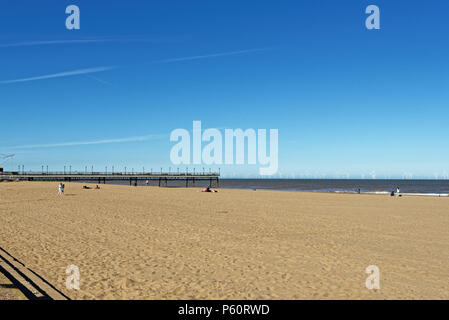 Skegness beach and pier with a wind farm on the horizon Stock Photo