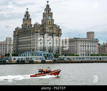 Merseyside Fire and Rescue rigid inflatable speed boat, River Mersey with city landmark Royal Liver building, Pier Head, Liverpool, England, UK Stock Photo
