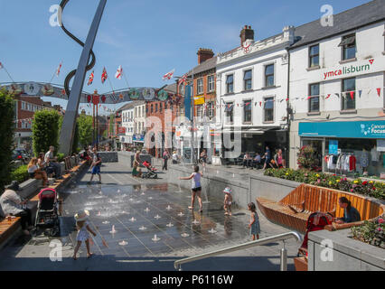 Lisburn, County Antrim, Northern Ireland. 27 June 2018. UK weather - a scorching hot day in the city of Liisburn with temperatures hitting 27C. Children play and cool off in the water jets in the town square. Credit: David Hunter/Alamy Live News. Stock Photo
