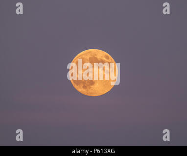 Mousehole, Cornwall, UK. 27th June 2018. Uk Weather.  The nearly full 'Strawberry' Moon, rises over the sea at Mousehole at sunset this evening. Credit: cwallpix/Alamy Live News Stock Photo