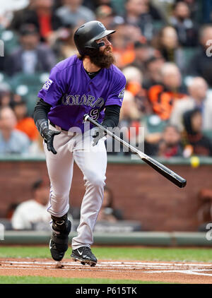 Colorado Rockies' Charlie Blackmon, left, shows to trainer Scott Gehret  where a foul ball hit his batting helmet as he stood in the on-deck circle,  during the third inning of the team's