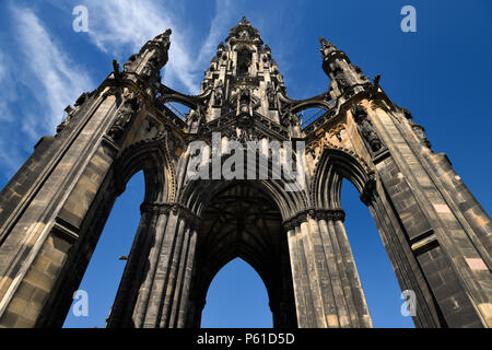 Looking up to the soot stained stones of the Sir Walter Scott Monument of Victorian Gothic architecture in Edinburgh Scotland UK with blue sky Stock Photo