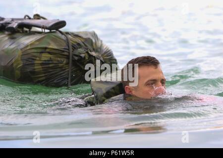 A paratrooper from the 307th Brigade Engineer Battalion, 3rd Brigade Combat Team swims across an obstacle while towing equipment during the Best Sapper Competition at Fort Leonard Wood, Missouri, on April 19, 2016. The event tests combat engineering skills, physical endurance, tactical problem solving, teamwork, operational readiness, and proficiency in mobility, obstacle navigation, and mission-oriented engineering tasks. Stock Photo