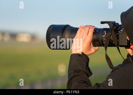 GDANSK, POLAND - May 5, 2018: Photographer holding camera lens and taking photo. Stock Photo