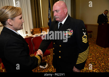 NORFOLK, Va. (Apr. 8, 2016) -- Cmdr. Julie Treanor, supply officer aboard Pre-Commissioning Unit Gerald R. Ford (CVN 78), awards Master Chief Ship's Serviceman Kenneth Carter a Meritorious Service Medal during his retirement at Vista Point Conference Center at Naval Station Norfolk. Carter retired after 30 years of service in the Navy, originally reporting to Recruit Training Command in Orlando, Florida, in 1986. (U.S. Navy photo by Mass Communication Specialist Seaman Apprentice Gitte Schirrmacher/Released) Stock Photo