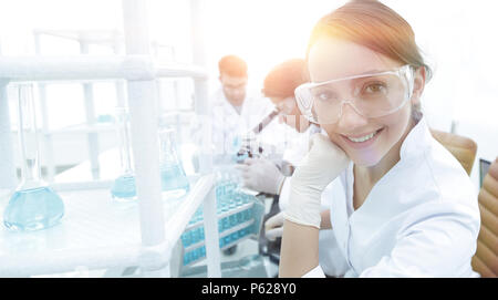 Investigator checking test tubes, Woman wears protective goggles Stock Photo
