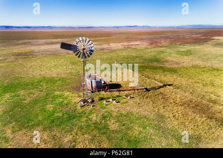 Old rusty windmill on a remote cattle ship farm on dry plains of Lake George in ACT and NSW in Australia. Stock Photo