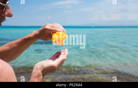 Senior man using sun protection cream on summer vacation Stock Photo