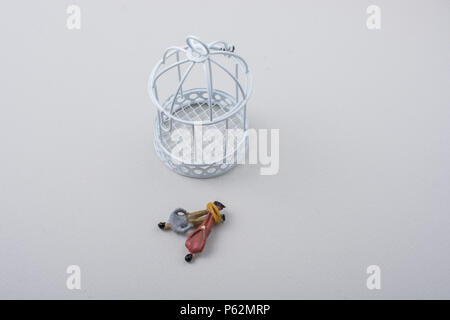 Tiny figurine of men  wrapped in rope beside a cage Stock Photo