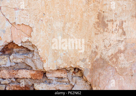 Old Cracked Weathered Shabby Yellow Painted Plastered Peeled Brick Wall Background. Stock Photo