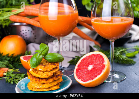 Juice from fresh carrots and grapefruit in a glass and fragrant pancakes for breakfast. vitamin drink for a healthy diet. Vitamins in food. Copy space Stock Photo
