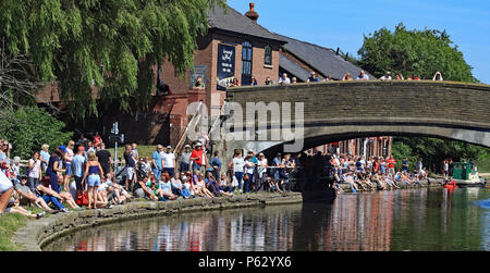 On a glorious summers Sunday the crowds line the Leeds and Liverpool canal for first rafts in the annual Heritage weekend to arrive at Burscough Wharf Stock Photo