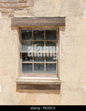 Old wood framed window with twelve glass panes, set in an adobe wall Stock Photo
