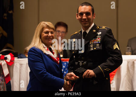 U.S. Army Sgt. Austin Berner, assigned to the 982nd Combat Camera Company (Airborne), accepts an award from U.S. Army Gen. (Ret.) Ann Dunwoody on behalf of the commander Maj. Cristopher Murphy during the Airborne Awards Festival at the Atlanta Airport Marriott Hotel, Atlanta Ga., April 16, 2016. The 39th Annual Airborne Awards Festival recognizes active duty and retired airborne soldiers of all services. It serves to extend the brotherhood of the airborne ethos. (U.S. Army photo by Pfc. Sharell Madden/Released) Stock Photo