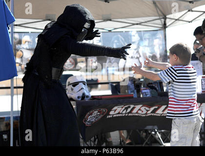 An actor portraying Kylo-Ren, a character from the movie Star Wars, interacts with a young patron at March Field Airfest in California, April 16, 2016. The Airfest features military and civilian aerial and ground demonstrations during a two-day air show. (U.S. Air Force photo by Tech Sgt. Stephen D. Schester/Released) Stock Photo