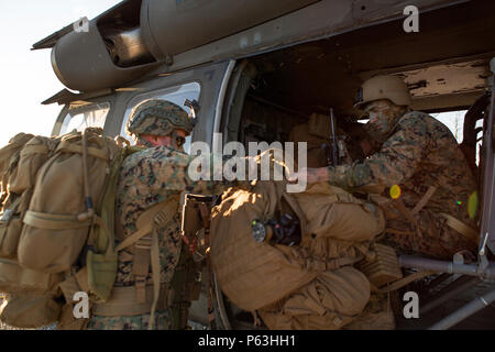 Scout Snipers with 2/24, 23rd Marine Regiment, 4th Marine Division, Marine Forces Reserve, scout sniper platoon, quickly load their packs into a Black Hawk Helicopter during a fire support coordination exercise in Camp Atterbury, Ind., April 14, 2016. The Reserve Marines were able to coordinate with Blackhawk’s from the U.S. Army, Company B, 8th Battalion, 229th Aviation Regiment (8-229 AV), 11th Aviation Command (Theater), during the exercise to accomplish their mission. Stock Photo