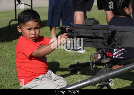 MARINE CORPS BASE CAMP PENDLETON, Calif. – A young boy plays with a M2 .50 caliber heavy machine gun during the 3rd Battalion, 5th Marine Regiment “Dark Horse” Reunion at the San Mateo Memorial Garden April 29, 2016. The reunion included a barbecue and a hike up First Sergeant’s Hill to honor the fallen Marines of 3/5 who were deployed to Sangin, Afghanistan in the fall of 2010. (U.S. Marine Corps photo by Lance Cpl. Shellie Hall/Released) Stock Photo